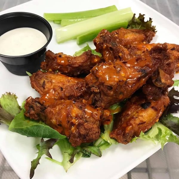 Sauder's Landing Restaurant's chicken wings, drizzled with sauce, served with celery sticks and ranch dip.